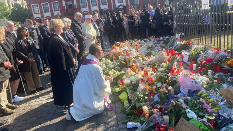 Vertreter der Mannheimer Religionsgemeinschaften legen Blumen am Marktplatzbrunnen nieder