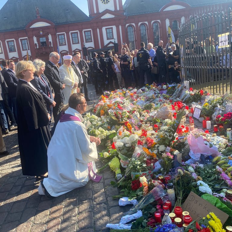 Vetreter der Mannheimer Religionsgemeinschaften legen Blumen am Marktplatzbrunnen nieder