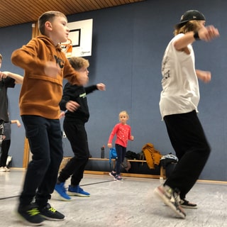 Kinder trainieren Breakdance in einer Turnhalle in Buchen