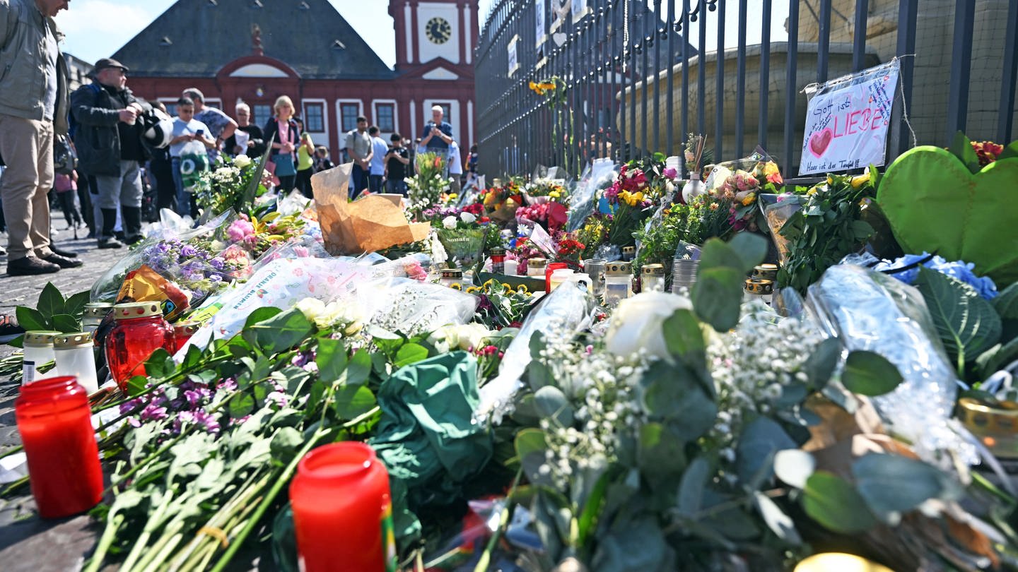 Nach dem Tod eines Polizisten, der nach einer Messerattacke mit mehreren Verletzten gestorben ist, liegen am Marktplatz in der unmittelbaren Nähe des Tatorts Blumen und Kerzen.