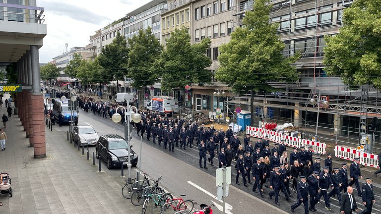 Polizistinnen und Polizisten ziehen in einem Trauerzug durch die Mannheimer Innenstadt.