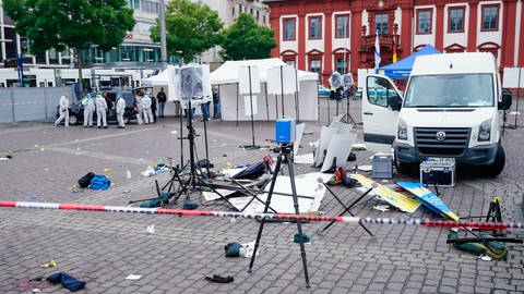 Mitarbeiter der Spurensicherung stehen auf dem Mannheimer Marktplatz hinter einem zertrümmerten Stand