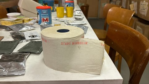 Ein Tisch im Atomschutzbunker Mannheim; darauf Klopapier und Essenskonserven
