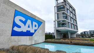 Ein Logo des Softwarekonzerns SAP auf einer grauen Wand vor einem SAP-Gebäude in Walldorf