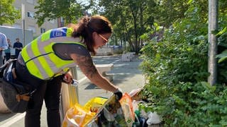 Sauberkeitsermittlerin Sabrina Brand untersucht in Mannheim-Waldhof Tüten mit illegal abestelltem Müll