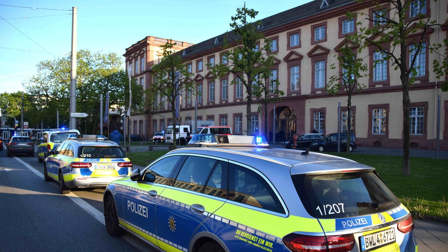 Fahrzeuge der Polizei stehen vor der Universität in Mannheim.