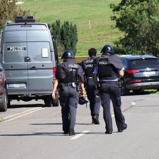 Polizisten in Schutzkleidung auf Straße - In Heiligkreuzsteinach läuft ein größerer Polizeieinsatz