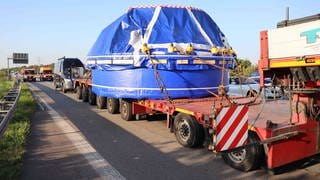 Schwertransporter auf der Autobahn, auf der Ladefläche steht ein 90 Tonnen schwerer Bohrkopf 