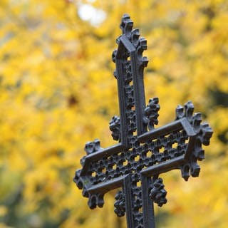 Ein eisernes Kreuz steht auf einem Friedhof