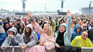 Fans jubeln den Mitgliedern der Band Tokio Hotel beim Glücksgefühle-Festival auf dem Hockenheimring zu.