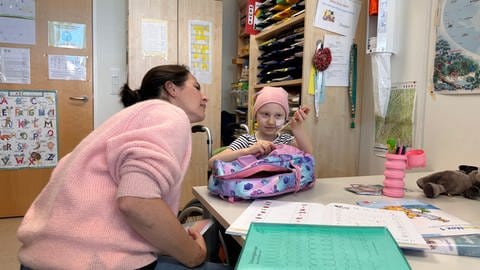 Diana und Grundschullehrerin Jana Barragán y Garcia erkunden am ersten Schultag ihren Schulranzen.