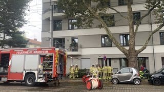 Feuerwehreinsatzkräfte und Feuerwehreinsatzwagen vor Wohnhaus in Mannheim 