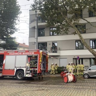 Feuerwehreinsatzkräfte und Feuerwehreinsatzwagen vor Wohnhaus in Mannheim 