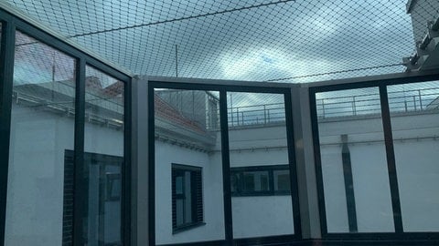 Ein Metallnetz ist über einen Balkon gespannt. Das Bild ist der Außenbereich der neuen psychatrischen Einrichtung