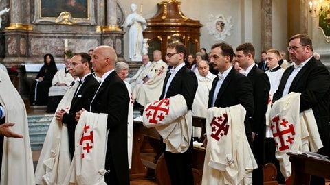 Die neuen Mitglieder des Ordens vom Heiligen Grab zu Jerusalem stehen in der Mannheimer Jesuitenkirche mit ihren neuen Roben