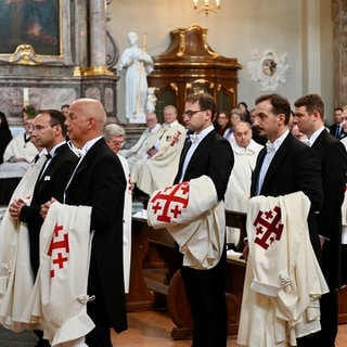 Die neuen Mitglieder des Ordens vom Heiligen Grab zu Jerusalem stehen in der Mannheimer Jesuitenkirche mit ihren neuen Roben