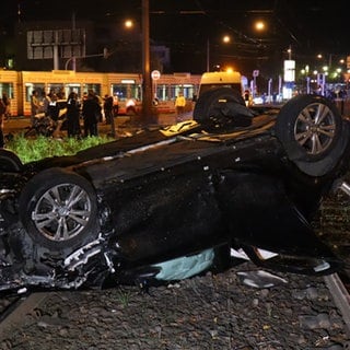 Ein Auto hat sich überschlagen und ist auf dem Dach im Gleisbett der Straßenbahn gelandet