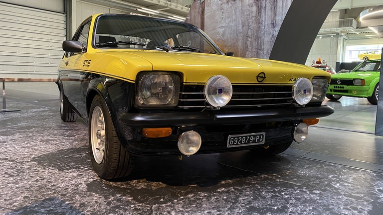 Ein gelb-schwarzer Opel Kadett mit Extra-Scheinwerfern