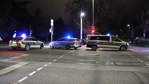 Einsatzwagen der Polizei sperren einen Bereich einer Straße bei der Ernst-Walz-Brücke in Heidelberg ab