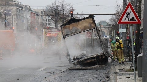 Der Klein-Lkw ist komplett ausgebrannt und raucht noch. Die Feuerwehr löscht den Brand.