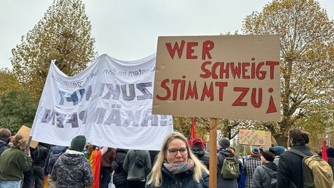 Eine Teilnehmerin der Proteste gegen den AfD-Landesparteitag in Ketsch mit ihrem Plakat: Wer schweigt stimmt zu