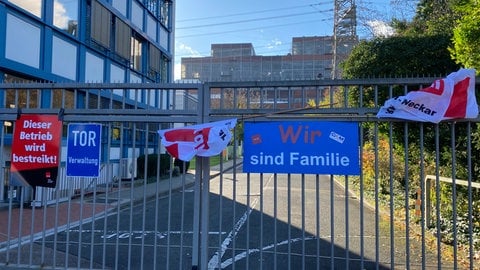 Streikplakate hängen an einem Tor des Großkraftwerks Mannheim