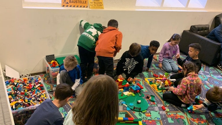 Die Schülerinnen und Schüler spielen Lego in der Kindervesperkirche.