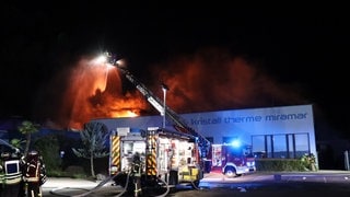 Feuerwehrleute löschen in der Nacht einen Brand im Freizeitbad Miramar in Weinheim (Rhein-Neckar-Kreis)