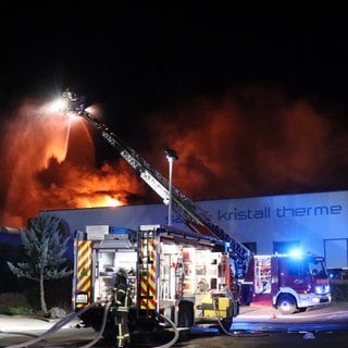 Feuerwehrleute löschen in der Nacht einen Brand im Freizeitbad Miramar in Weinheim (Rhein-Neckar-Kreis)