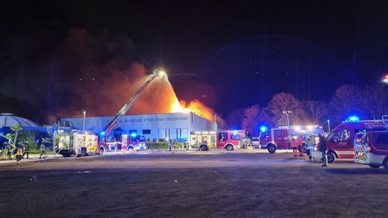 Feuerwehrleute löschen in der Nacht einen Brand im Freizeitbad Miramar in Weinheim (Rhein-Neckar-Kreis)