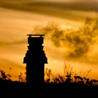 Schornstein mit Rauch am Abendhimmel