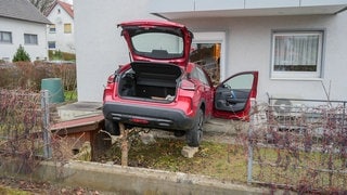 Ein Auto steckt in einem Wohnhaus