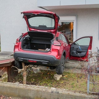 Ein Auto steckt in einem Wohnhaus