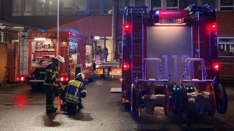 Feuerwehrleute vor Klinikgebäude