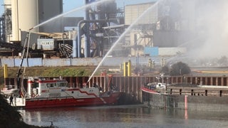 Auch ein Feuerlöschboot ist bei dem Brand im Industriehafen in Mannheim im Einsatz.