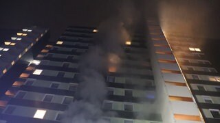 In einem 14-stöckigen Hochhaus im Heidelberger Stadtteil Emmertsgrund brennt es. Rauch steigt aus einem Fenster.