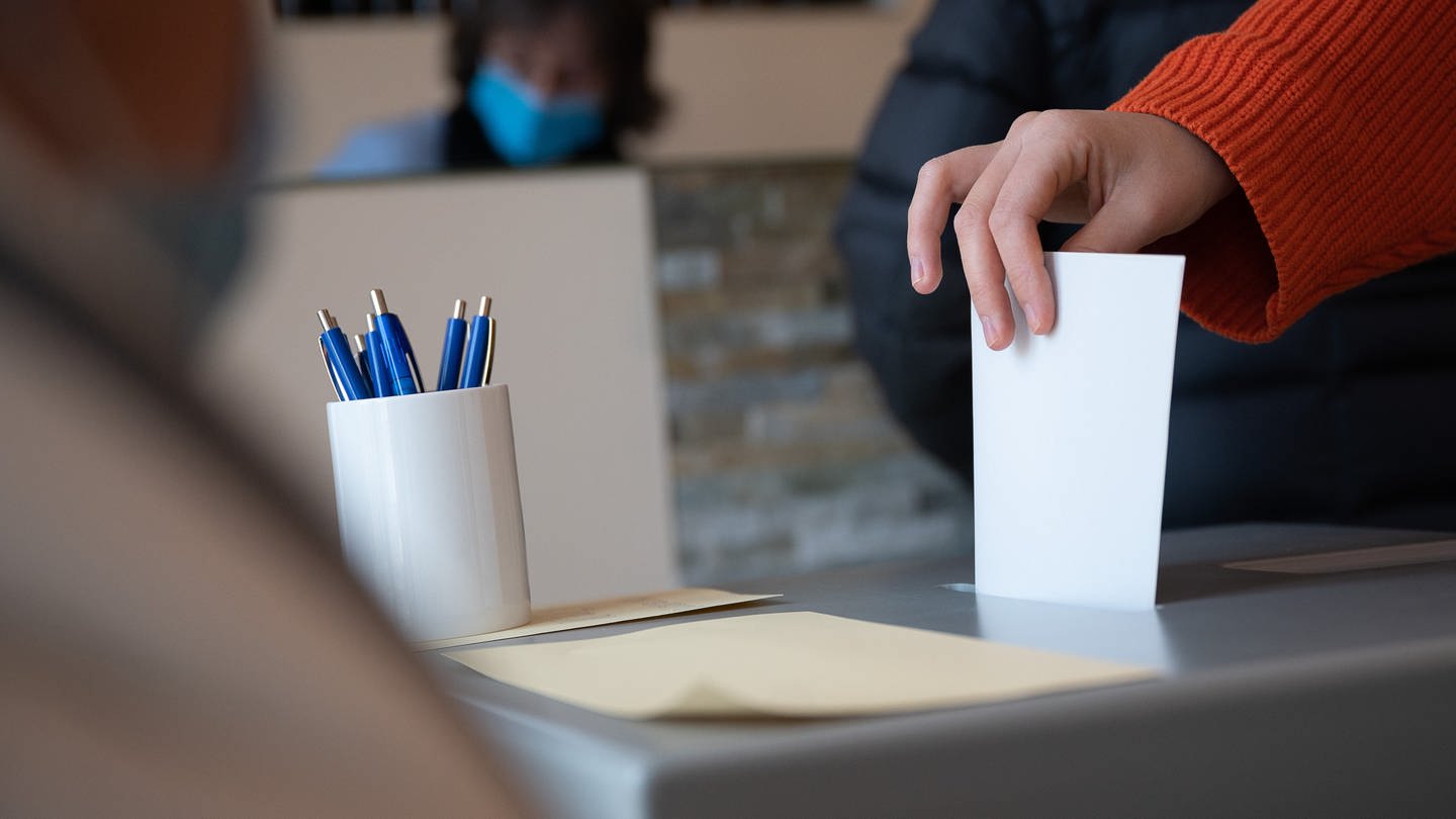 Stimmzettel vor beim Einwurf in eine Wahlurne