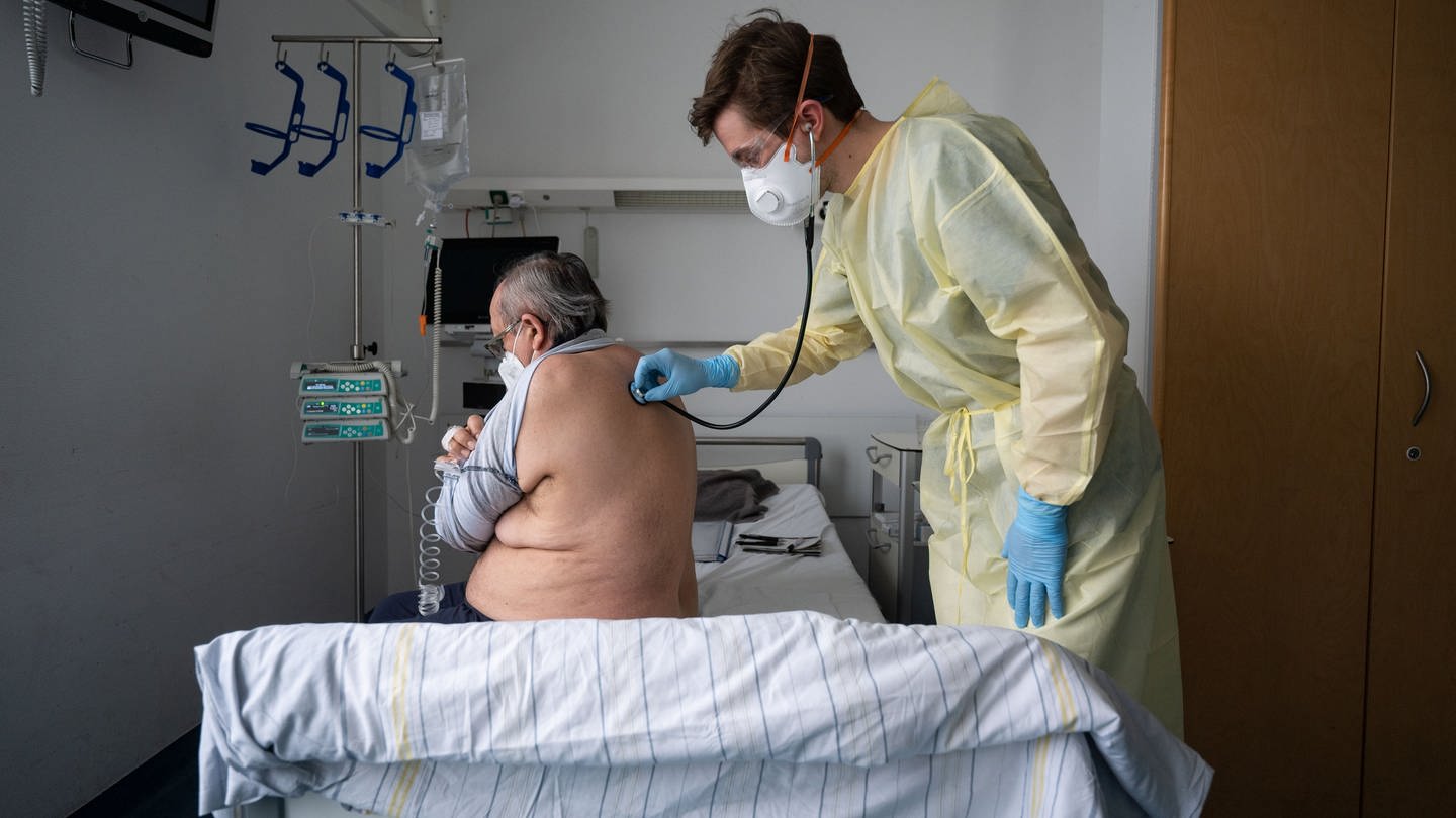 Ein Oberarzt versorgt einen Patienten am Klinikum Stuttgart.
