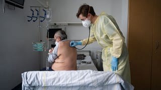 Ein Oberarzt versorgt einen Patienten am Klinikum Stuttgart. 