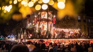 Die Krippenpyramide auf dem Schlossplatz ist eine der Hauptattraktionen auf dem Weihnachtsmarkt Stuttgart. Trotz Energiekrise darf sie adventlich erstrahlen.