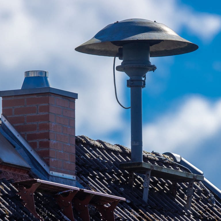 Eine Alarmsirene steht auf einem Hausdach. 