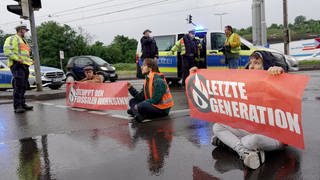 Klimaktivisten der "Letzen Generation" demonstrieren auf Straße in Stuttgart