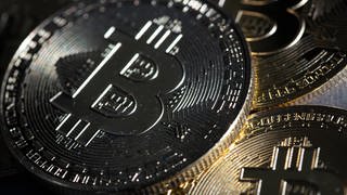 Bitcoin-Münzen (Token) liegen auf einem Tisch.