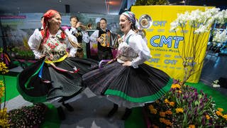 Sogenannte "Laderinnen" des Vereins "Bauerngman Villach" aus Österreich tanzen bei einem Fototermin am Vortag der Eröffnung der Reisemesse CMT in den Hallen der Messe Stuttgart.