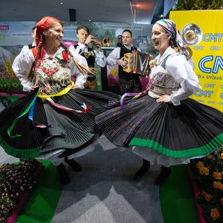 Sogenannte "Laderinnen" des Vereins "Bauerngman Villach" aus Österreich tanzen bei einem Fototermin am Vortag der Eröffnung der Reisemesse CMT in den Hallen der Messe Stuttgart.