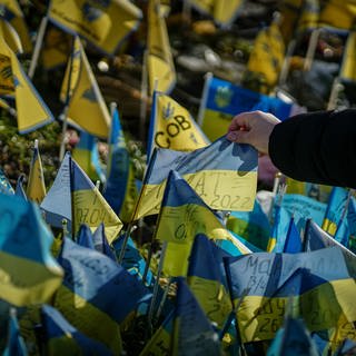 Am Jahrestag des Angriffs Russlands auf die Ukraine finden in der Region Stuttgart viele Veranstaltungen statt. Auf dem Bild schaut sich eine Passantin die Beschriftung auf einer ukrainischen Flagge für die getöteten Soldaten am Maidan an.