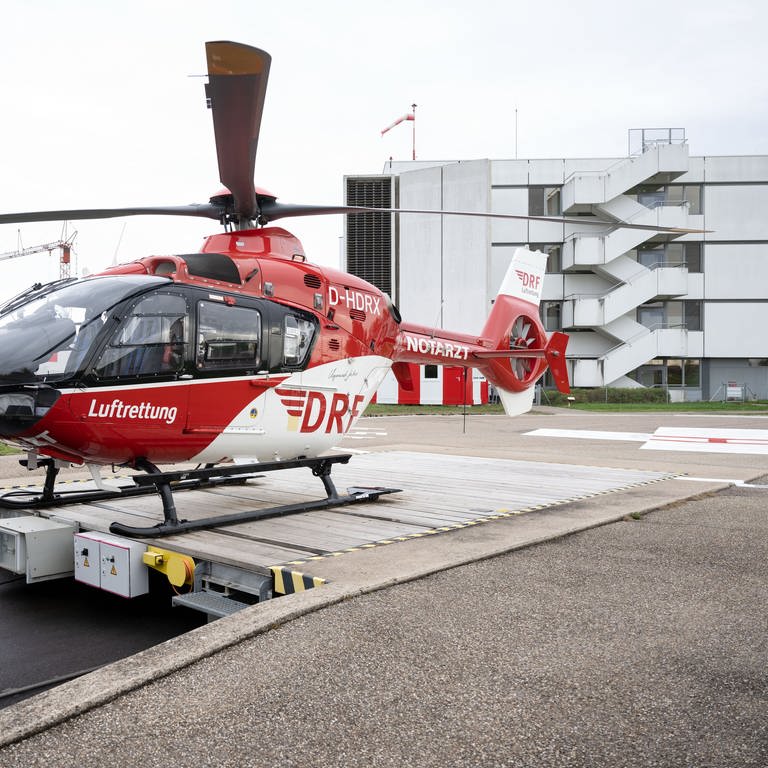 Ein Rettungshubschrauber steht auf dem Helikopterlandeplatz der Station Leonberg der DRF Luftrettung, im Hintergrund ist das Krankenhaus Leonberg zu sehen. 
