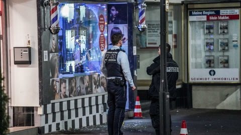 Polizisten vor beschädigtem Schaufenster in Plochingen