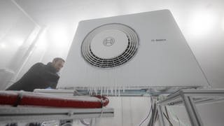 Bosch-Mitarbeiter öffnet Klimakammer einer Wärmepumpe