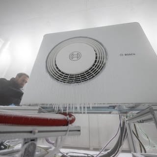 Bosch-Mitarbeiter öffnet Klimakammer einer Wärmepumpe